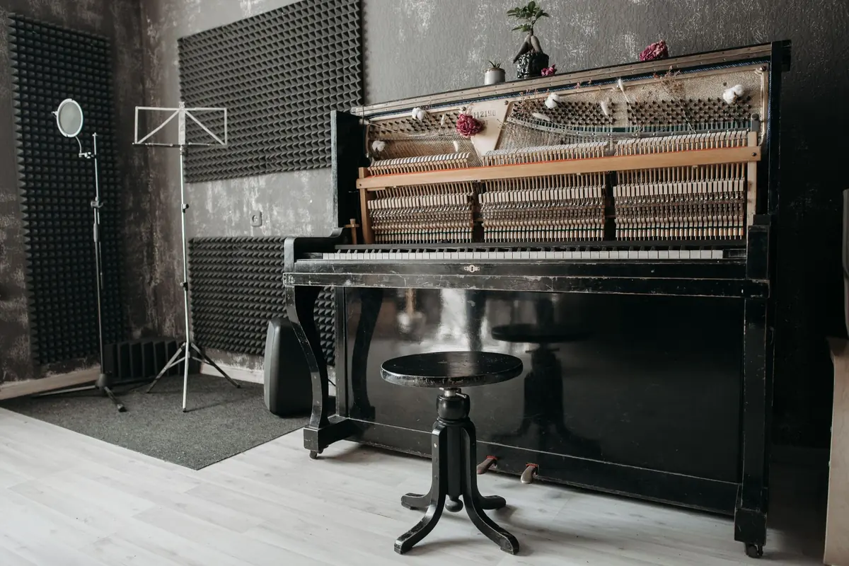 Ein aufrechtes Klavier steht frei zugänglich in einem Musikraum