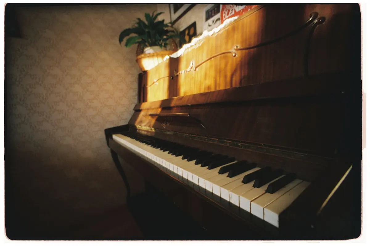 Ein aufrechtes Klavier steht an einer Wand in einem hellen Zimmer