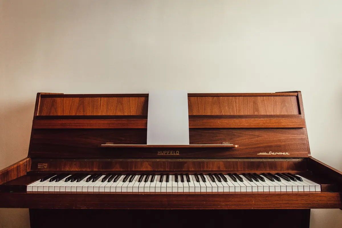 Ein klassisches Klavier steht mit Sitzbank in einem Wohnraum