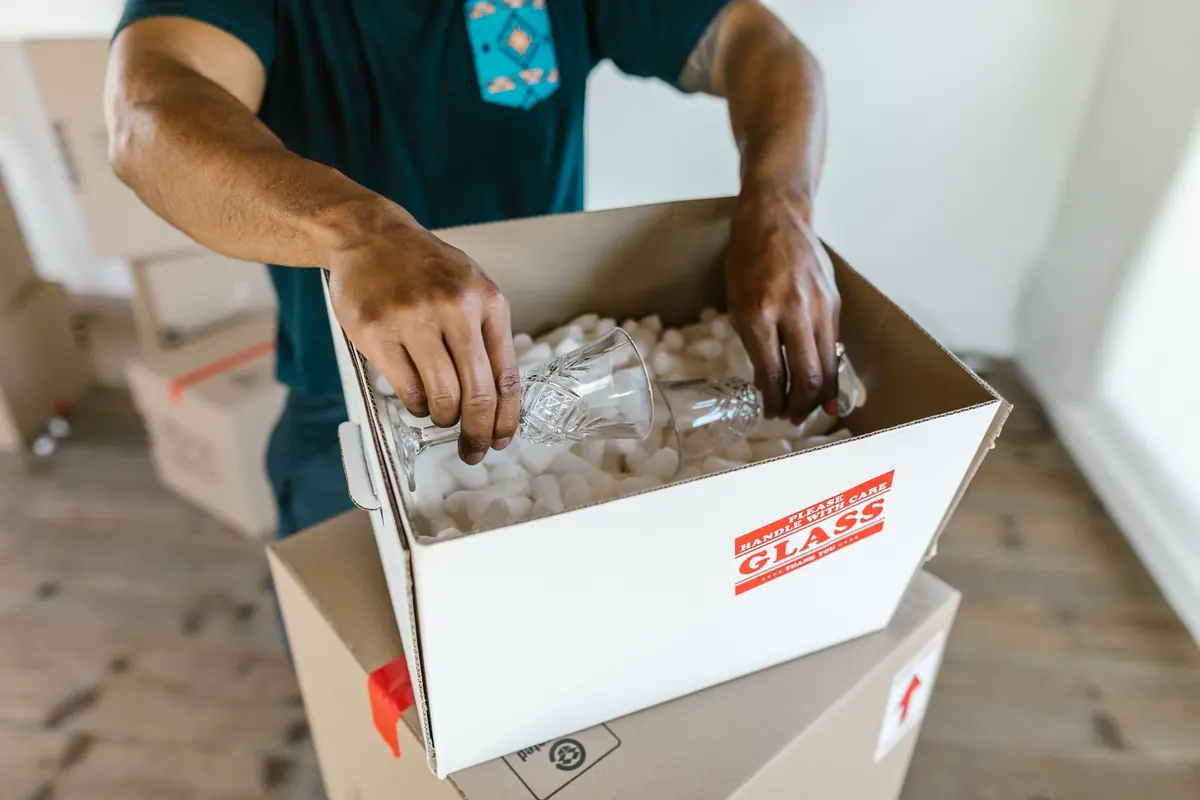 Zerbrechlicher Hausrat wird geschützt in einen Karton gepackt
