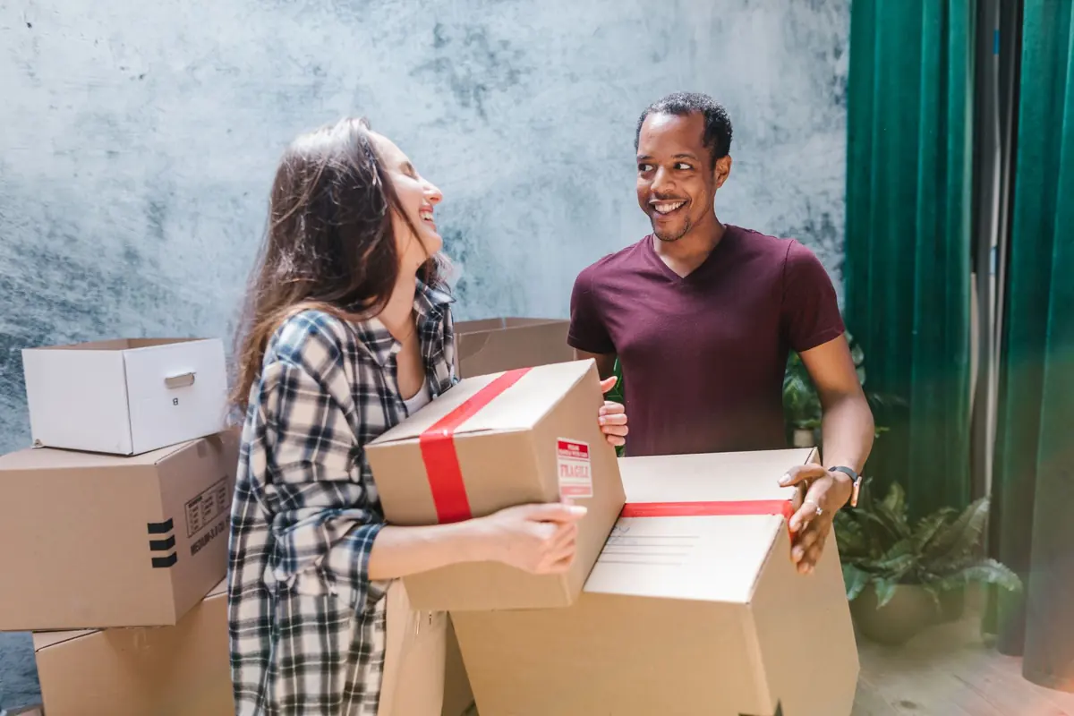 Zwei Personen übergeben einen gepackten Karton